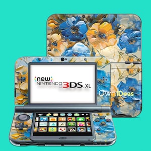 Puede incluir: Una consola New Nintendo 3DS XL con un diseño floral en azul, amarillo y blanco. La consola está abierta, mostrando la pantalla y los controles. El texto "new Nintendo 3DS XL" es visible. La marca "OwniDeas" también es visible.