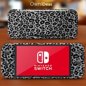 May include: A black and gray leopard print skin for a Nintendo Switch console. The skin covers the entire console, including the joy-cons.