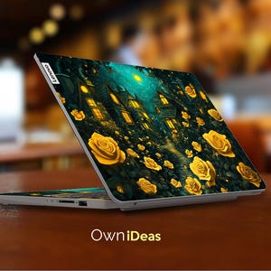 Puede incluir: Un ordenador port&aacute;til con un fondo azul oscuro y verde que presenta una escena caprichosa de casas y rosas amarillas. El port&aacute;til tiene el logotipo de Lenovo en la tapa.