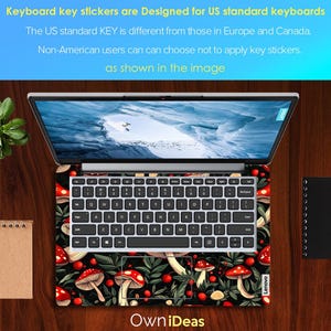 May include: Laptop with a keyboard skin featuring a pattern of red mushrooms, green leaves, and berries on a black background. The laptop screen displays a snowy landscape. The keyboard has white keys. The text "Own iDeas" is visible.