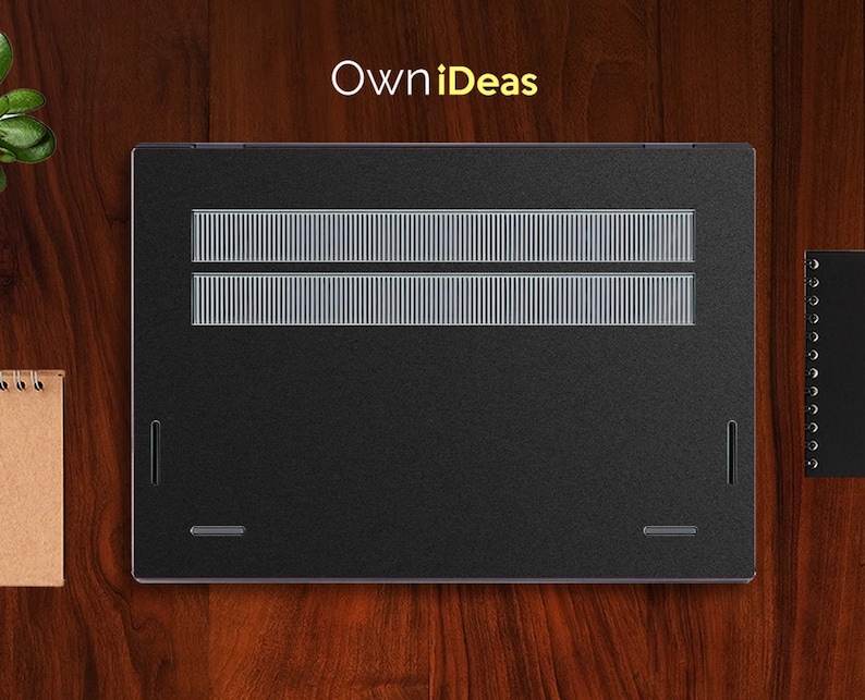 May include: Black laptop computer with a silver grill on the back. The laptop is on a wooden surface.