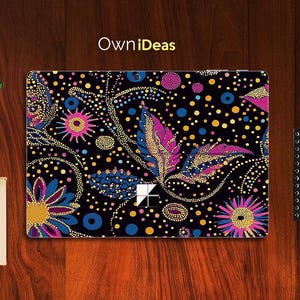 Puede incluir: Una piel para portátil negra con un diseño abstracto colorido con puntos y remolinos rosas, azules y amarillos. El diseño se asemeja a un patrón paisley con un toque moderno.