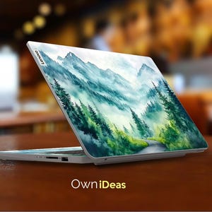May include: A white laptop with a watercolor design of a mountain range and a winding road through a forest. The laptop has the word "Lenovo" on the back.