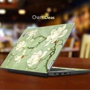 May include: A green laptop skin with a floral design featuring white magnolia blossoms. The skin is designed for a Lenovo laptop. The text "OwnIdeas" is printed on the skin.
