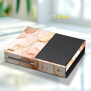 May include: A pink and gold marble design Xbox console skin with the text "OwnIdeas" on the top.