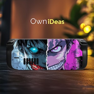 May include: Black handheld gaming console with a split-face graphic design. One side features a blue-toned character with a glowing eye and exposed teeth, the other a purple-toned character with a menacing grin. The text "OwniIdeas" is above the console.