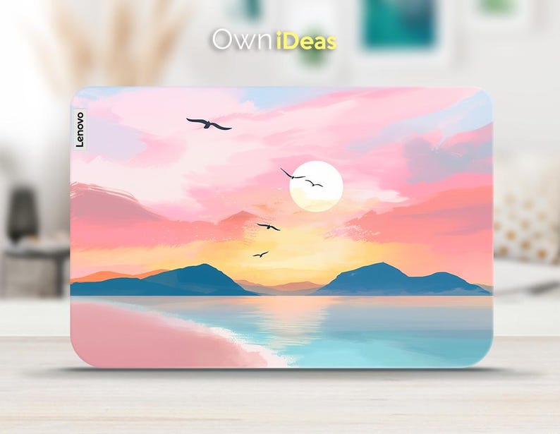 Op de afbeelding: Een Lenovo laptop skin met een zonsondergang boven de oceaan. Het ontwerp toont een heldere zon, vogels in vlucht en een kleurenpalet van roze, oranje en blauw. De tekst "Own iDeas" is zichtbaar.