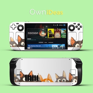 May include: White handheld gaming console with a black and white illustration of cats peeking out from the sides. The screen displays the game "Play Aperture Desk Job" and the game "Cocoon".