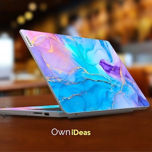 K&ouml;nnte beinhalten: Ein Laptop mit einem abstrakten Design in Blau, Lila und Rosa auf dem Deckel. Das Design verf&uuml;gt &uuml;ber goldene Akzente und &auml;hnelt einem Aquarellbild. Der Laptop ist ge&ouml;ffnet und das Lenovo-Logo ist auf dem Deckel sichtbar.