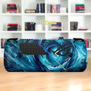 May include: A handheld gaming console with a blue and white swirling water design. The console features the text "OwniDeas" and the ROG logo. The design includes a black vent and colorful accents.