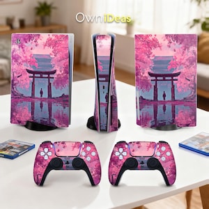 Puede incluir: Una consola PlayStation 5 y dos mandos con un diseño de flores de cerezo rosas y moradas. La consola y los mandos presentan un paisaje de inspiración japonesa con una puerta torii y una persona junto al agua.