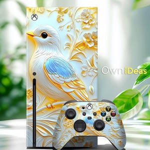 May include: A white and gold Xbox Series X console and controller skin with a detailed floral design and a white bird with blue accents. The design features a 3D embossed effect.
