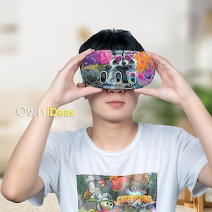 Op de afbeelding: Een kleurrijke VR-headset met een wasbeer met een hartvormige zonnebril. De headset heeft een levendig ontwerp met roze, paarse en oranje accenten. De tekst "OwniDeas" is zichtbaar.