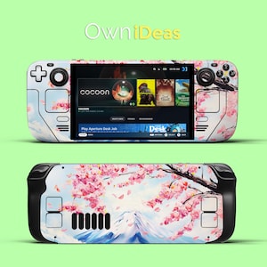 Könnte beinhalten: Ein weiß-schwarzes Handheld-Gaming-Gerät mit einem bunten Blumenmuster auf der Rückseite. Der Bildschirm zeigt ein Spiel namens "Play Aperture Desk Job" und den Text "cocoon".