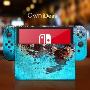 Könnte beinhalten: Eine türkisfarbene und braune Nintendo Switch Konsolenhaut mit einem verwitterten, rostigen Metalldesign. Die Haut wird auf die Konsole und die beiden Controller aufgebracht. Das Nintendo Switch Logo ist auf dem Bildschirm sichtbar.