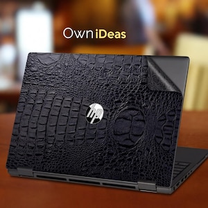 May include: A black laptop with a textured, crocodile-skin-like design on the lid. The HP logo is visible in the center. The laptop is on a brown table, with the text "OwniDeas" in the background.