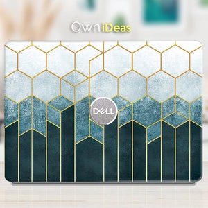 Puede incluir: Una piel para portátil con un patrón geométrico de líneas doradas y cuadrados azules y blancos. La piel tiene un logotipo de Dell en el centro.