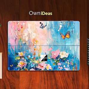 Puede incluir: Una pintura abstracta colorida con mariposas y flores. La pintura está sobre un fondo azul con acentos rosas, blancos y amarillos. La pintura está dividida en dos secciones, la sección superior muestra un diseño más abstracto y la sección inferior muestra una representación más realista de las flores.