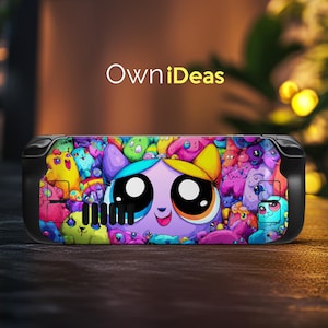 May include: A black handheld gaming device case with a vibrant cartoon design. The design showcases a large-eyed character with a purple face, surrounded by colourful cartoon creatures. The text "OwniIdeas" is displayed in white on the case.