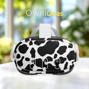 May include: VR headset with a black and white cow print design. The headset has a white strap and ear pieces. The text "OwniDeas" is displayed in yellow above the headset.