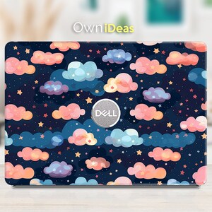 Könnte beinhalten: Eine Laptop-Haut mit einem farbenfrohen Design aus Wolken und Sternen auf dunkelblauem Hintergrund. Die Haut hat das Wort "DELL" in einem silbernen Kreis in der Mitte.