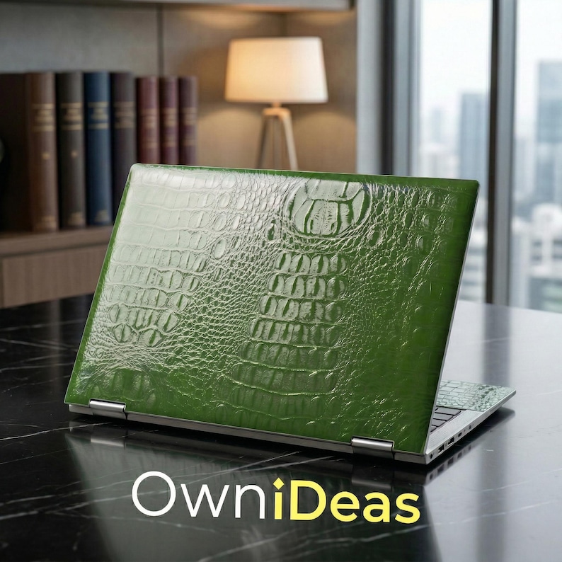 May include: Green laptop skin with a crocodile texture. The laptop is open, revealing the keyboard and screen. The brand name "OwniDeas" is displayed in white and yellow text at the bottom of the image.