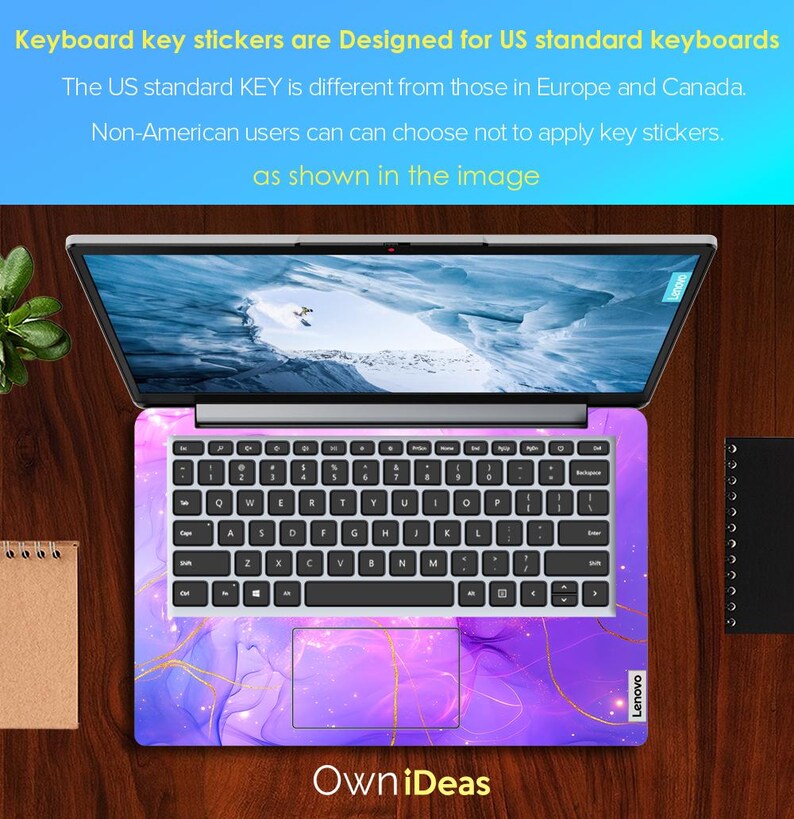May include: A laptop computer with a purple and gold keyboard sticker. The sticker features a marbled design with gold accents. The laptop is open and the screen is showing a blue sky with clouds. The text "Own iDeas" is printed below the laptop. The text "Lenovo" is printed on the bottom right corner of the laptop.