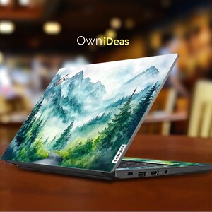May include: A laptop computer with a watercolor design of a mountain range with a road winding through it. The design is in shades of blue, green, and white. The laptop is closed and the design is on the top of the lid. The laptop brand is Lenovo.
