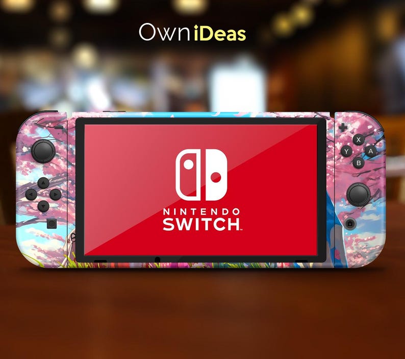 May include: A pink and blue Nintendo Switch console with a floral design. The console has a red screen with the Nintendo Switch logo and text.