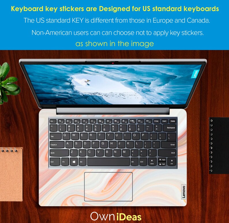 May include: A laptop computer with a white marble-patterned keyboard sticker. The sticker features a swirling pattern of white, peach, and light brown. The laptop is open and the screen shows a snowy mountain scene. The text "OwniDeas" is visible below the laptop.