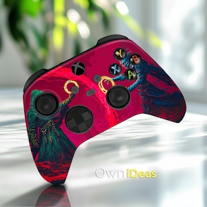 May include: A pink and red Xbox controller with a graphic of a wizard and a creature with wings. The controller has the letters X, Y, A, and B on the top.