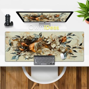 以下が含まれることがあります： 花柄のデザインが施された大きなマウスパッドで、女性が花畑に横たわっている様子が描かれています。マウスパッドはベージュで、薄い茶色の縁取りがされています。女性は白いドレスを着ており、長い茶色の髪をしています。花は白とピンクです。