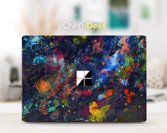 May include: A laptop skin with a colorful abstract design featuring splashes of paint in various colors, including blue, red, yellow, and green, on a dark blue background. The skin has the Microsoft Windows logo in the center.