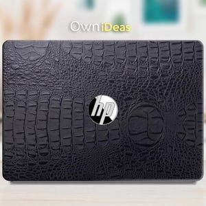 Puede incluir: Funda negra para portátil con textura de cocodrilo. El logotipo de HP está centrado en la funda. El texto "OwnIdeas" está en la esquina superior izquierda.