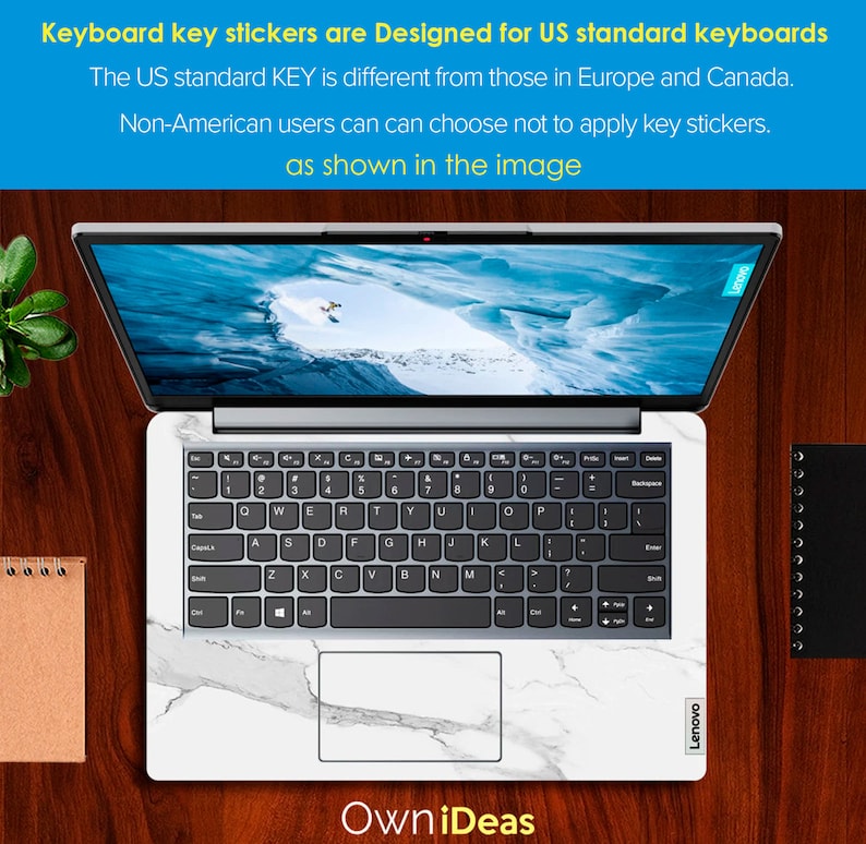 May include: A white laptop with a marble design keyboard sticker. The laptop is open and the screen shows a snowy mountain scene. The text "OwniDeas" is visible below the laptop. The text "Lenovo" is visible on the right side of the laptop.