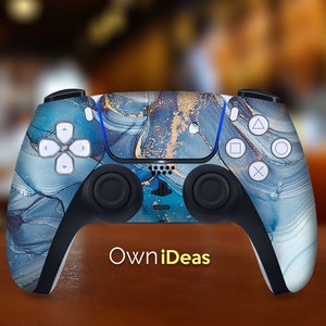 May include: A blue and gold PlayStation 5 controller with a marble pattern. The controller has the PlayStation logo and the text "OwnIdeas" on the front.