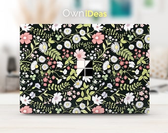 May include: A black laptop skin with a floral pattern featuring white, pink, and green flowers. The skin has the text "OwnIdeas" printed on it.