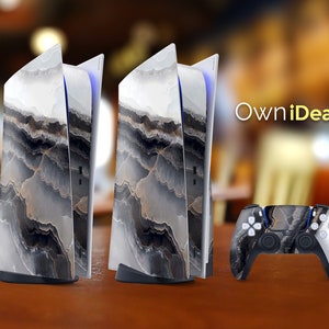 Könnte beinhalten: Zwei weiße und schwarze Playstation 5 Konsolen mit einem passenden Marmormuster auf dem Controller. Die Konsolen haben einen weißen und blauen Lichtstreifen auf der Vorderseite. Der Text "OwnIdeas" ist im Hintergrund sichtbar.