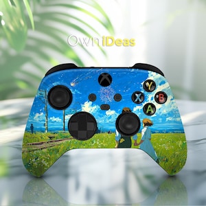 May include: A custom Xbox controller featuring a vibrant anime-style landscape with a blue sky, green fields, and figures. The controller has black buttons and triggers, with the Xbox logo and the text "OwniDeas" visible.