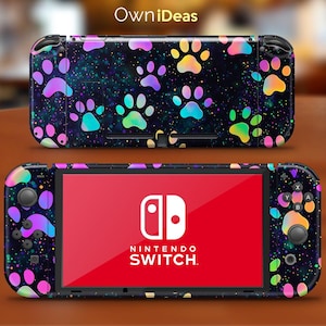 May include: A black Nintendo Switch console with a colourful paw print design. The console has a black screen with the Nintendo Switch logo and text.
