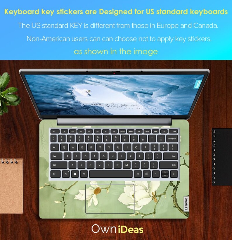 May include: A laptop computer with a green and white floral keyboard sticker. The sticker features a magnolia flower design. The text "Own iDeas" is printed on the bottom of the image. The text "Lenovo" is printed on the bottom right corner of the laptop.