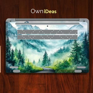 May include: A laptop skin with a watercolor design of a misty forest scene. The design features a winding road through the trees and a light blue sky.