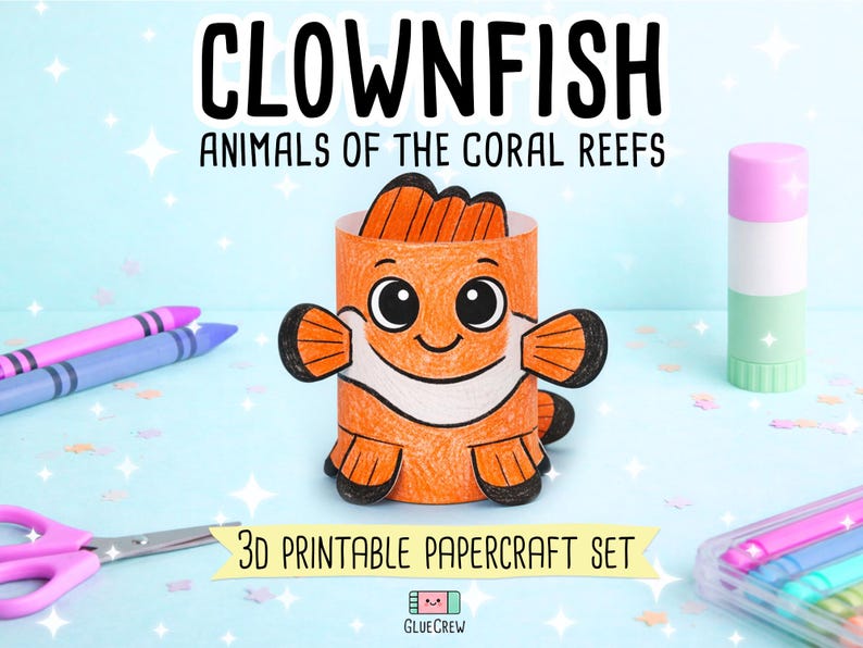 May include: A 3D papercraft clownfish figure coloured in orange, white, and black. The text CLOWNFISH ANIMALS OF THE CORAL REEFS and 3D PRINTABLE PAPERCRAFT SET is visible. Crafting supplies including crayons, scissors, and a glue stick are present.