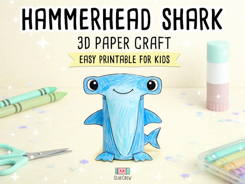 以下が含まれることがあります： 「HAMMERHEAD SHARK 3D PAPER CRAFT EASY PRINTABLE FOR KIDS」の文字が入った、青い3Dペーパークラフトのシュモクザメ。 クレヨン、ハサミ、のりなどの画材に囲まれています。