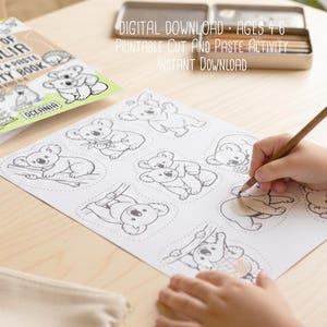 May include: A coloring and cut-and-paste activity book titled "Animals of Australia" with koala illustrations. The image shows a child coloring a koala drawing with a pencil. Text on the image reads "DIGITAL DOWNLOAD - AGES 4-6 PRINTABLE CUT AND PASTE ACTIVITY INSTANT DOWNLOAD".