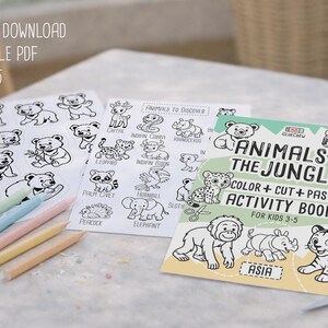 Op de afbeelding: Een kinderactiviteitenset met printbare kleurplaten en een boek "Dieren van de Jungle". De set bevat kleurpotloden en een schaar. De tekst luidt "Direct downloaden, PDF afdrukken, Leeftijd 3-5".