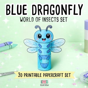 Op de afbeelding: Een 3D-papieren libellefiguur in blauwtinten met grote ogen en vleugels. De tekst luidt BLUE DRAGONFLY WORLD OF INSECTS SET en 3D PRINTABLE PAPERCRAFT SET. Het figuur is omringd door kleurpotloden, een schaar en een lijmstift.