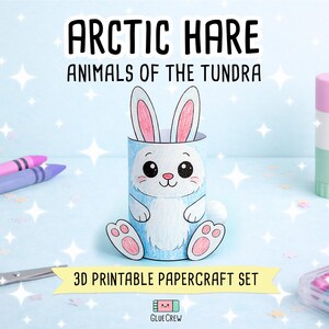 Puede incluir: Una figura de papel 3D de una liebre &aacute;rtica en blanco y azul claro, con orejas rosas y una cara de dibujos animados. El texto dice ARCTIC HARE ANIMALS OF THE TUNDRA y 3D PRINTABLE PAPERCRAFT SET. Se ven materiales de manualidades como ceras y pegamento.