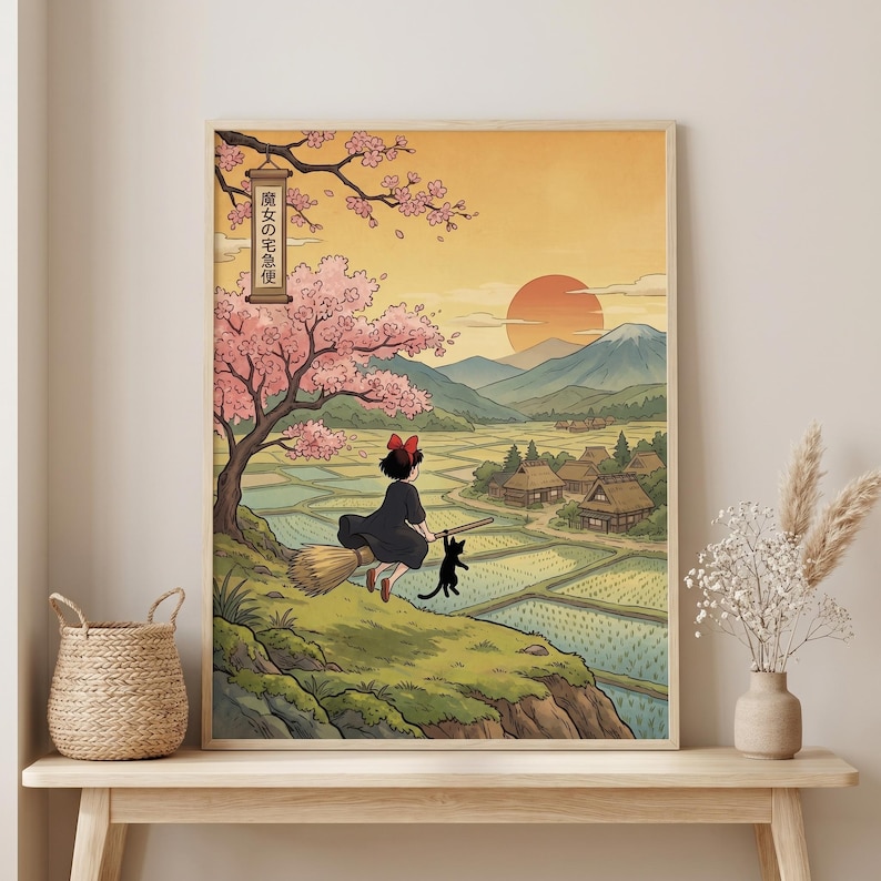 May include: A framed art print featuring a young witch on a broom with a black cat, flying over a rural landscape with rice paddies, mountains, and a setting sun. The print has Japanese text and cherry blossoms.