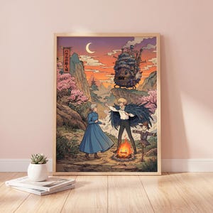 May include: A framed art print featuring a scene from a Japanese animated film. The artwork depicts characters in a fantasy landscape with a castle, a bonfire, and a crescent moon in the sky. The color palette includes shades of orange, pink, and blue.